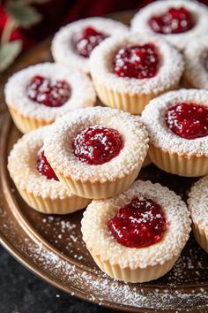 small pastries with powdered sugar and jelly on a platter, ready to be eaten