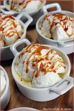 several desserts with caramel drizzle and whipped cream in white bowls on a wooden table