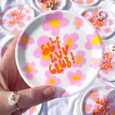 a person holding up a plate with flowers on it