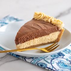 a slice of chocolate cheesecake on a white plate with a gold fork next to it