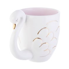 a white swan shaped mug with gold detailing