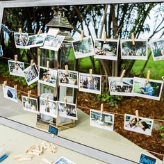 several pictures are hanging on clothes pins in front of a window with photos pinned to them