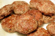 several hamburger patties sitting on top of a white plate