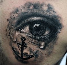 a close up of a man's chest with an eye and anchor on it