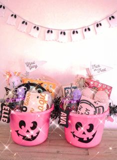 two pink buckets filled with candy and decorations