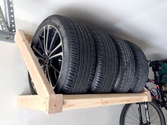 a bicycle is parked next to a rack with several tires hanging on it's side