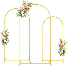 three gold arches with pink and white flowers hanging from the top, along with greenery on each side