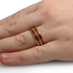 This solid 14k yellow gold wedding band features koa wood inlays, and a gold string surrounded by polished titanium. Unique and handmade, this symmetrical design highlights the inlaid string. Great for that special musician in your life! RING LAYOUTRing Width: 8 mmRing Sleeve: 14k Yellow GoldRing Profile: FlatRing Finish: Polished 0.75 mm 14k Yellow Gold2 mm Koa Wood0.5 mm Titanium1.5 mm Guitar String0.5 mm Titanium2 mm Koa Wood0.75 mm 14k Yellow Gold Rock N Roll Wedding, Engraving Fonts, Koa Wood, Custom Guitar, Wood Inlay, Engraved Rings, Accessories Unique, Custom Rings, Gold Bands