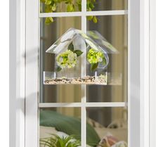 a bird house with flowers in it sitting on a window sill