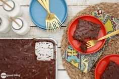 two red plates with brownies on them next to some forks