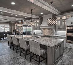 a large kitchen with an island and marble counter tops