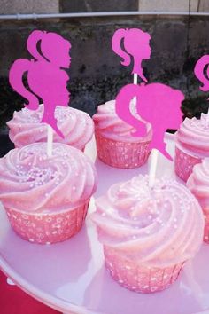 cupcakes with pink frosting are on a plate