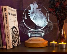 a wooden table topped with two books and a light up heart on top of it