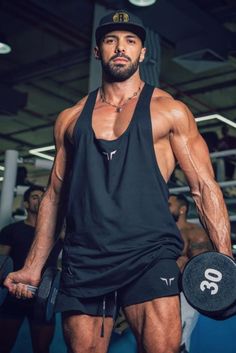 a man in black shirt and shorts holding a barbell