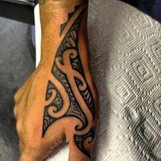 a man's hand with a tattoo design on the middle of his left arm