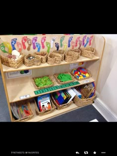 a shelf filled with lots of toys and baskets on top of it's sides