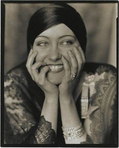 an old black and white photo of a smiling woman with her hands on her face