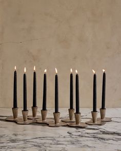 a group of candles sitting on top of a table next to each other with one candle in the middle