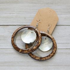 two wooden hoops with silver discs on them sitting next to a brown card board