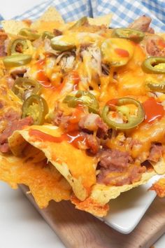 a cheesy nacho sitting on top of a white plate