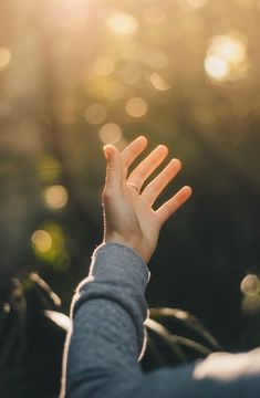 the person is reaching out their hand to catch something in the air with both hands