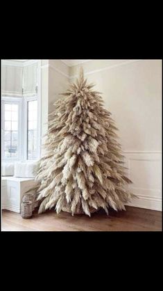 a white christmas tree sitting in the middle of a living room next to a window