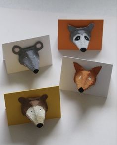 four small animal heads are placed in different shapes and sizes, each with an individual's face