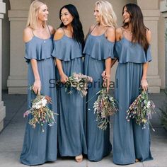 bridesmaids in blue dresses standing together and smiling at each other with their bouquets