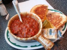 a bowl of chili and grilled cheese on a plate