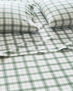 a green and white checkered bed spread with two pillow cases on top of it