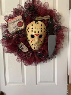 a hockey mask hanging on the front door with other items attached to it's face