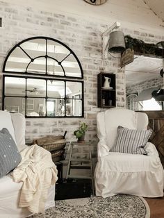 a living room filled with furniture and a clock on the wall above it's windows