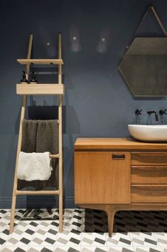 a bathroom with a sink, mirror and wooden ladder