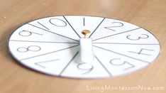 a white clock with numbers on it sitting on a table