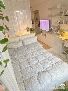 a bed sitting in a bedroom next to a desk with a computer on top of it