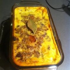 a casserole dish with meat and cheese in it sitting on a counter top