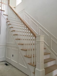 a white staircase with wooden handrails in a house