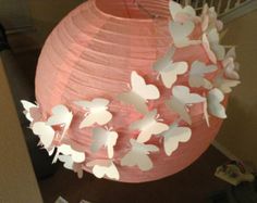 a pink paper lantern with white butterflies on it