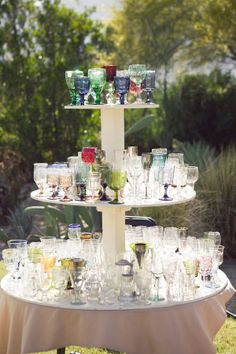 there are many glasses on the table and one is stacked high with it's bottom tier