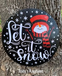 a wooden sign that says, let it snow on the side of a tree trunk