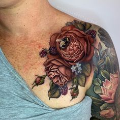 a woman's chest with flowers and a bee on the top part of it