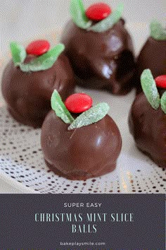 chocolate covered candies on a plate with green leaves and red berries in the middle