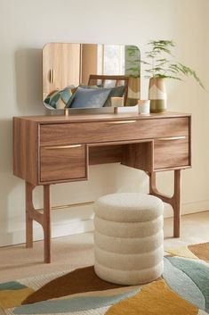 a wooden desk with a mirror and stool