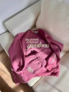 The Pursuit of Human Greatness Sweatshirt - Sugar Plum – The Happy Camp3r Pink School Spirit Sweatshirt, Sweatpant Designs, Sweatshirt Photoshoot Ideas, Sweatshirt Photoshoot, Cool Merch Ideas, Popular Sweatshirts, Merch Branding, Pilates Sweatshirt, Trending Sweatshirts