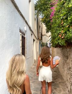 two women walking down a narrow alley way