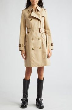 The iconic Burberry Heritage trench coat is expertly cut from water-resistant cotton gabardine with all the classic details, including the check lining. 38" length (size 8) Double-breasted button closure Point collar with throat latch Belted cuffs Front button-welt pockets Epaulets Button gun flap; storm flap Removable belt Back vent Lined 100% cotton with leather buckles Dry clean Made in the UK Designer Clothing Parisian Chic Style, Beige Trench Coat, Burberry Outfit, Fall Wardrobe Essentials, Street Style Parisian, Burberry Trench, Burberry Trench Coat, Classic Trench Coat, Double Breasted Trench Coat