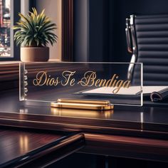 a desk with a pen, notebook and plant on it in front of a window