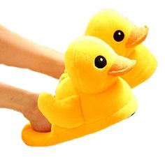 two yellow rubber ducks sitting on top of a carpet next to someone's feet