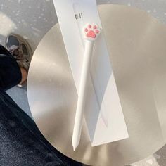 a white toothbrush sitting on top of a silver table next to a person's feet