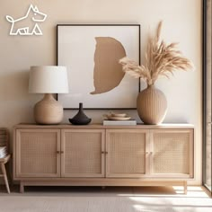 a living room with two vases and a lamp on the sideboard next to it